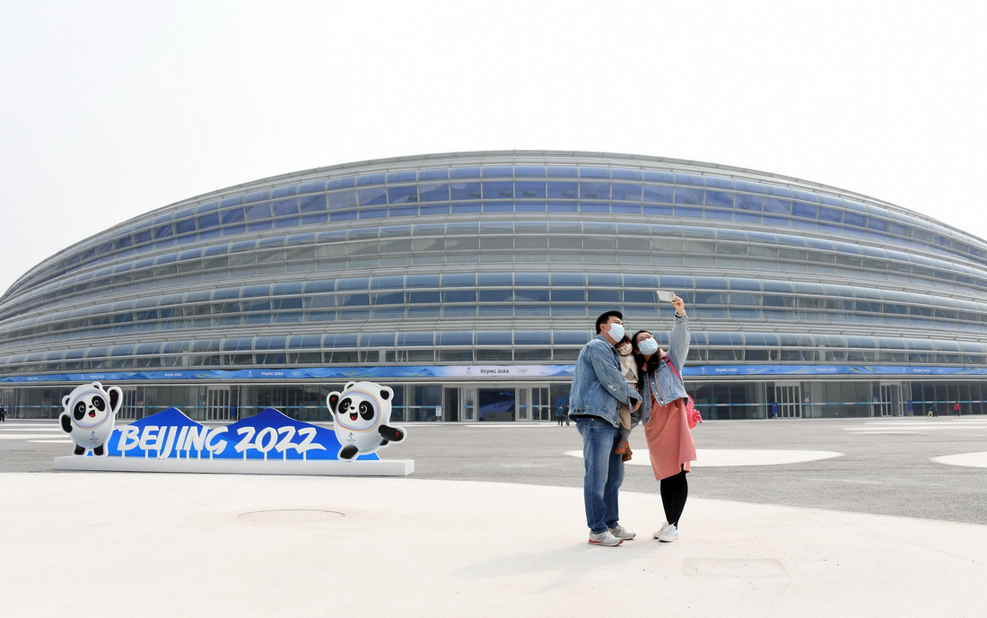 建设者张博伟（左）与家属在国家速滑馆“冰丝带”外合影留念（4月10日摄）。