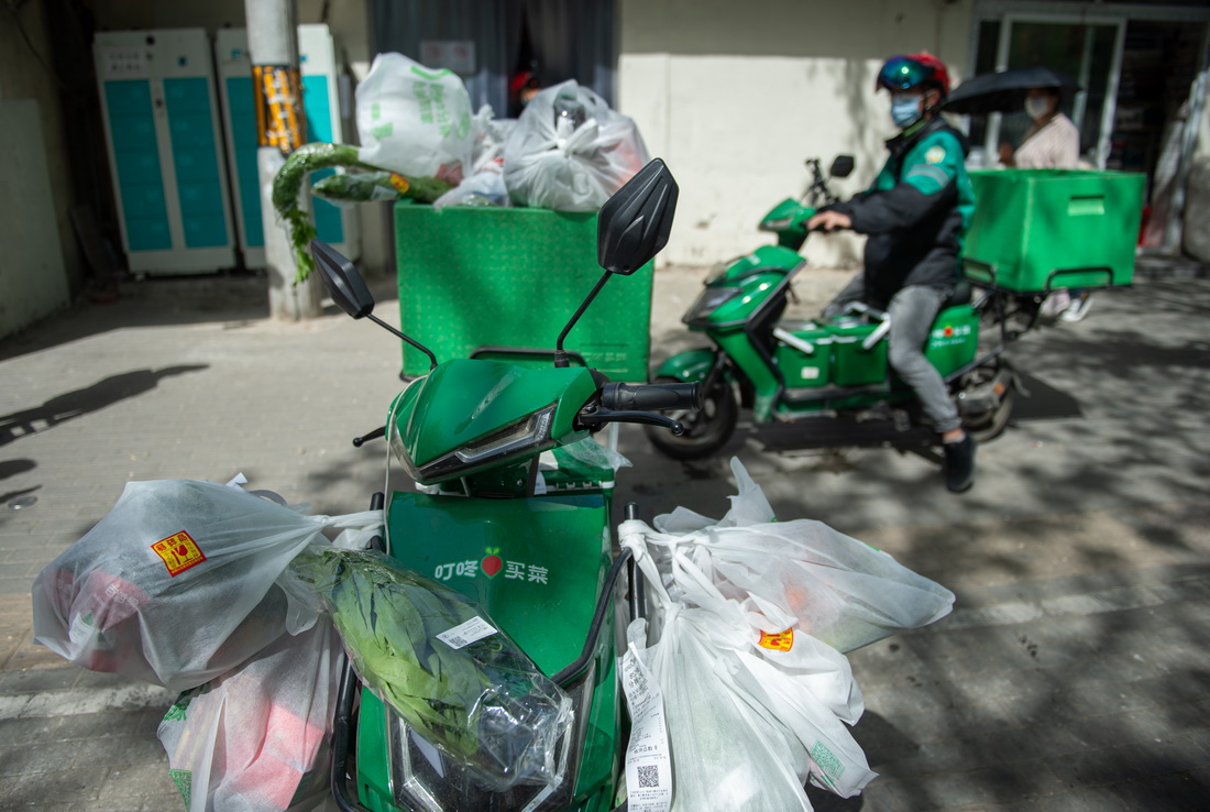 4月26日,在北京市朝阳区十里堡的叮咚买菜前置仓配送站外,一辆电动车