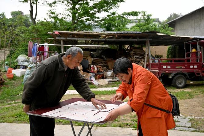 我在现场·照片背后的故事｜大山里，这位收废品老人的捐款收据铺满一桌