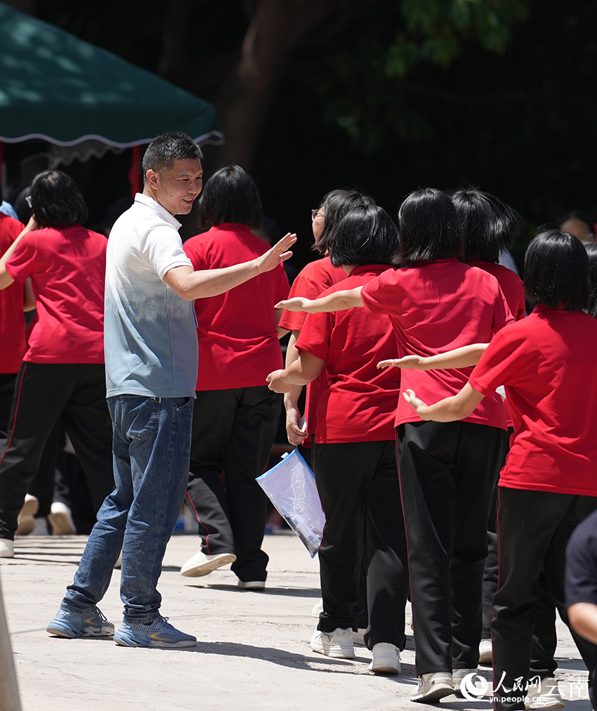 2026高考首日 张桂梅再陪大山女孩赴考场 老师为等待进入考场的考生加油打气。人民网记者 李发兴摄